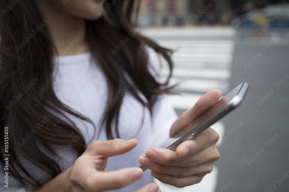 年轻女性在城市里使用智能手机