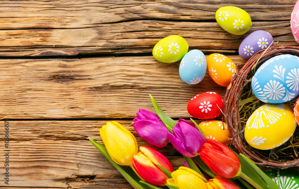 木制背景的复活节彩蛋和郁金香