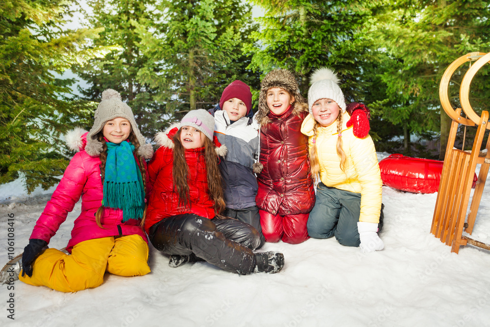 一群冬天坐在雪地上的孩子