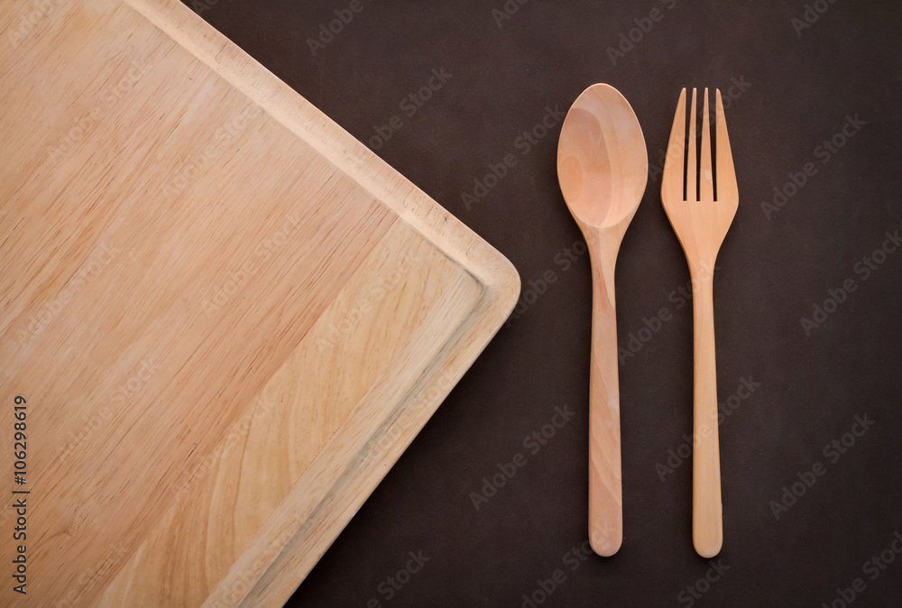 wooden spoon and fork on cutting pad