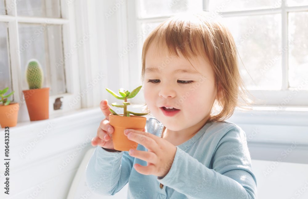  Happy toddler girl playing with potted plants