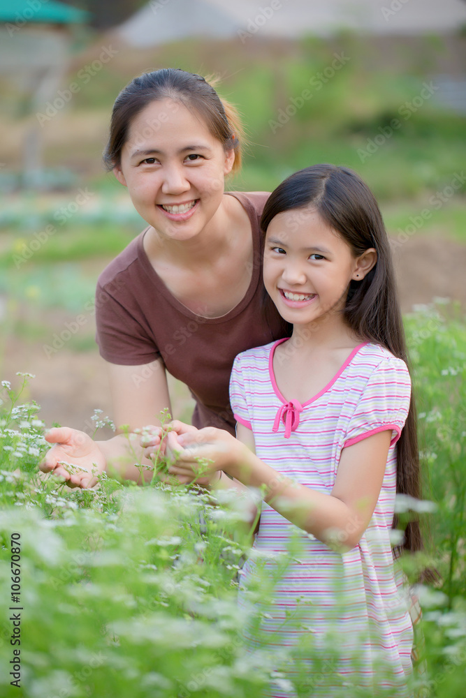快乐的亚洲女儿与母亲一起园艺