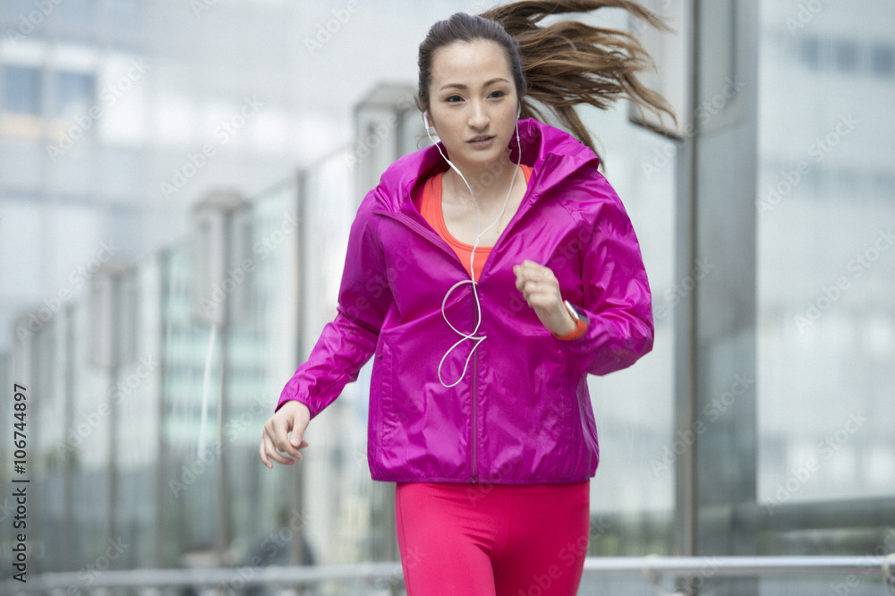 亚洲女性带智能手表慢跑