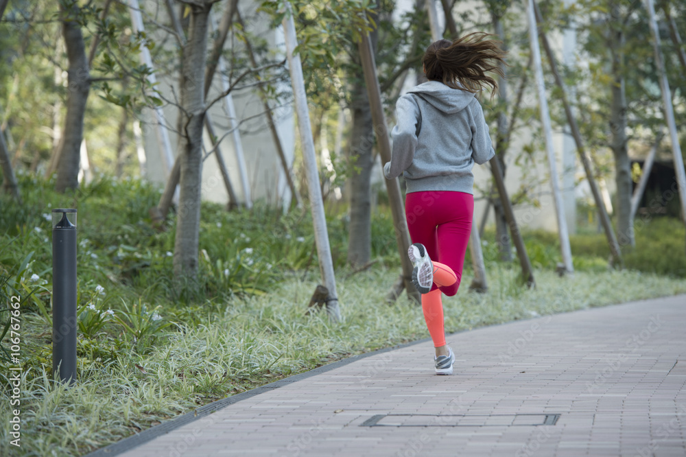 一名年轻女子在公园慢跑的背影