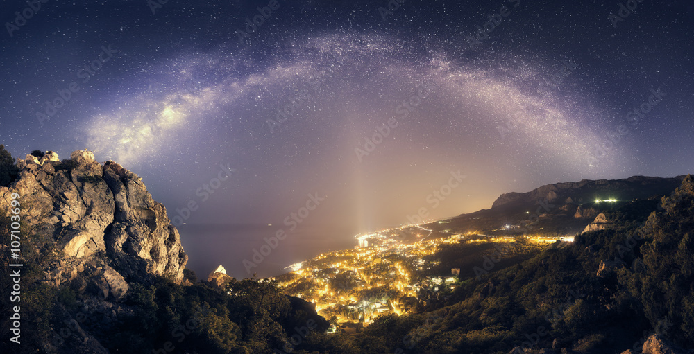Beautiful night landscape with Milky Way against city lights