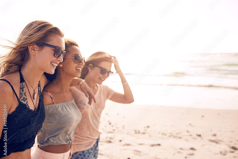 快乐的年轻女人走在海滩上