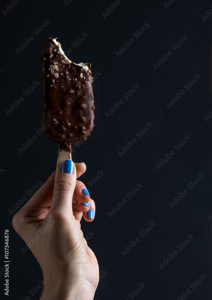 巧克力蘸冰棍冰淇淋，黑色女士手拿坚果碎