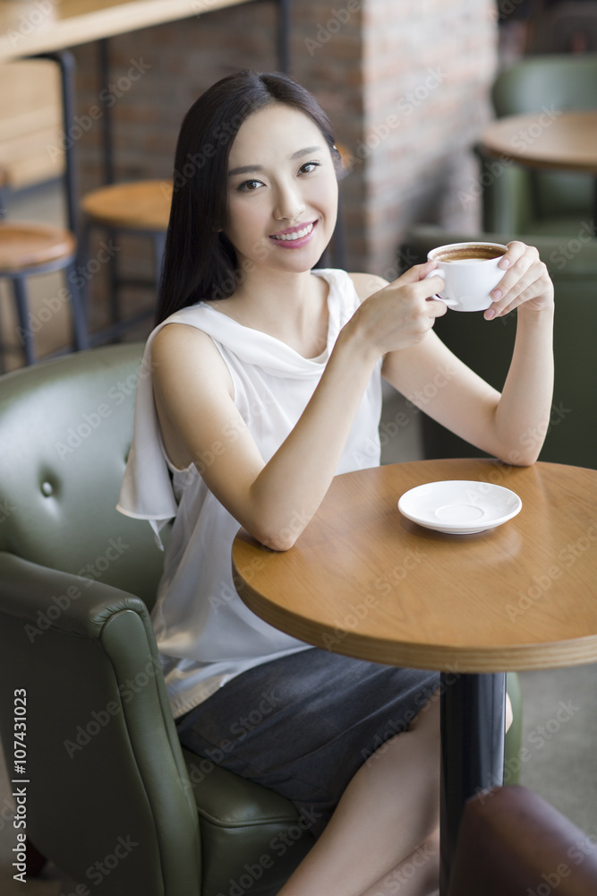 年轻女子在咖啡馆喝咖啡_