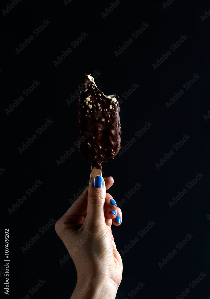 巧克力蘸冰棍冰淇淋，黑色女士手拿坚果碎