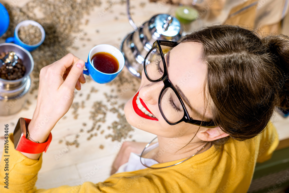 Top view portrait of a young woman drinking alternative coffee brewed in chemex on the wooden table 