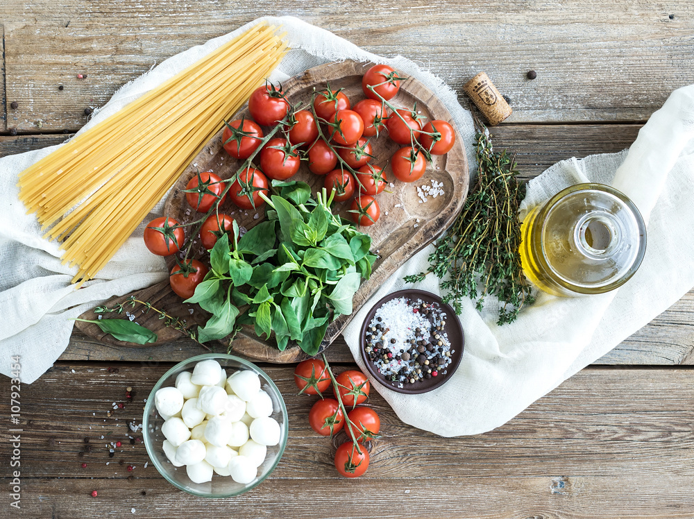 Ingredients for cooking pasta. Spaghetti, basil, cherry-tomatoes, mozarella, olive oil