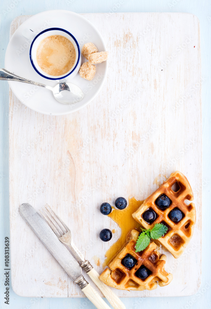 浓缩咖啡杯，柔软的比利时华夫饼，配新鲜蓝莓和涂有白色油漆的马普糖浆