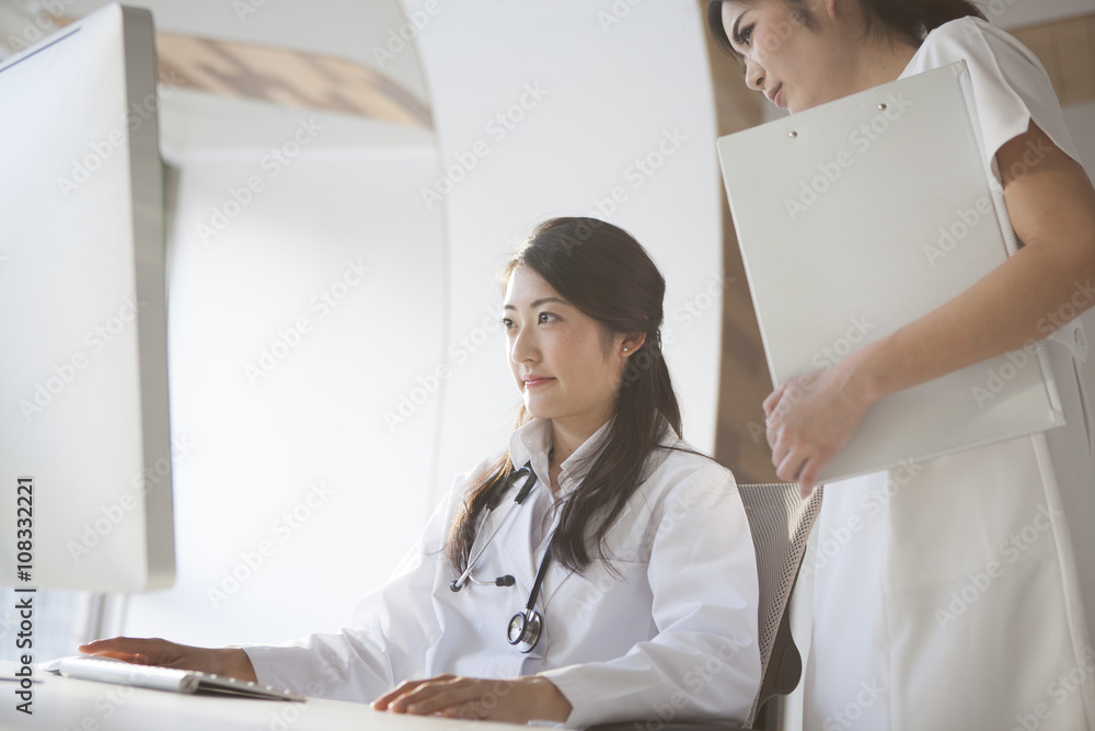 医生和护士正在看着个人电脑的屏幕