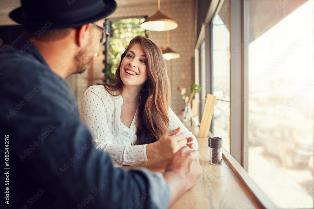 微笑的年轻女子和她的男朋友在咖啡馆
