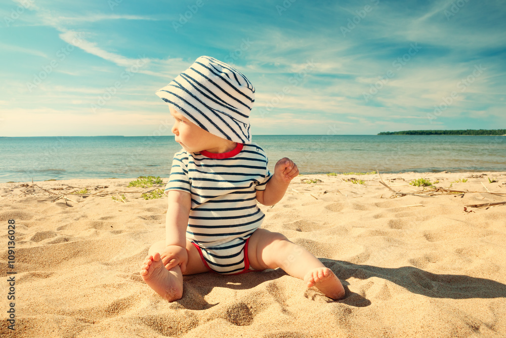 夏日坐在海滩上的小男婴