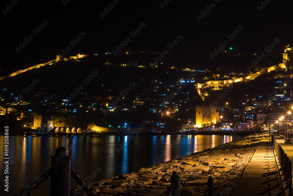 土耳其阿拉尼亚港口、堡垒和古代造船厂的夜景。