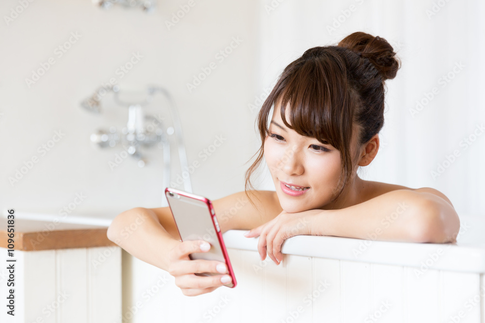 年轻的亚洲女人在浴缸里放松