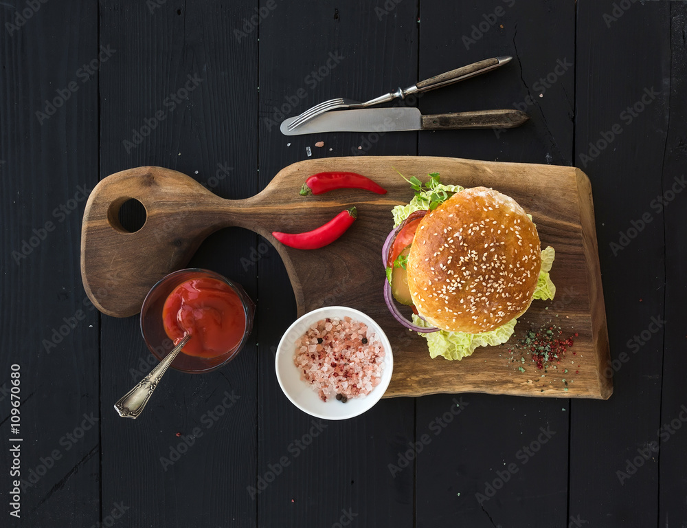 深色餐盘上的新鲜自制汉堡，配辣番茄酱和海盐