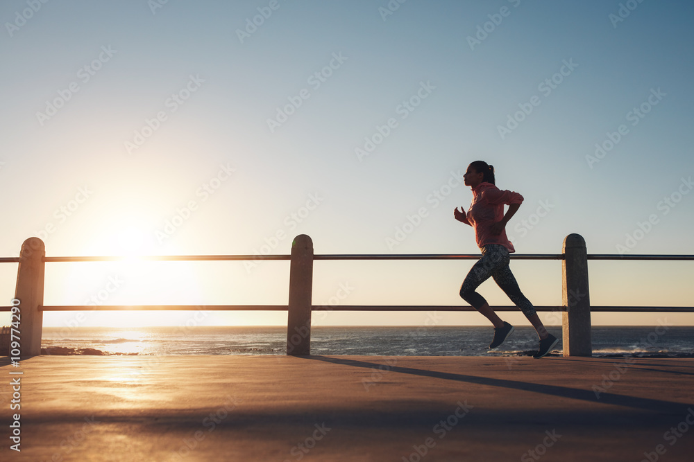 女运动员在海边的路上跑步
