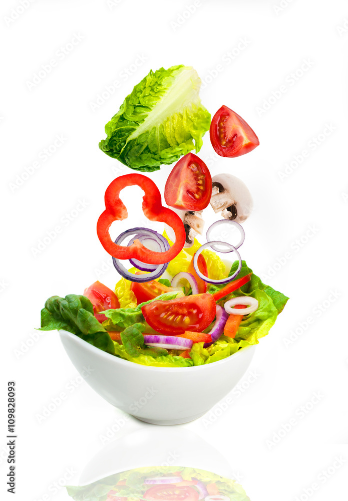 frischer Salat - Zutaten fallen in Schüssel