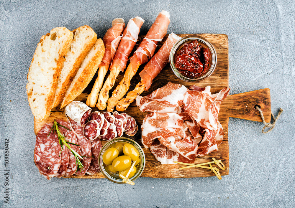 Meat appetizer selection or wine snack set. Variety of smoked meat, salami, prosciutto, bread sticks