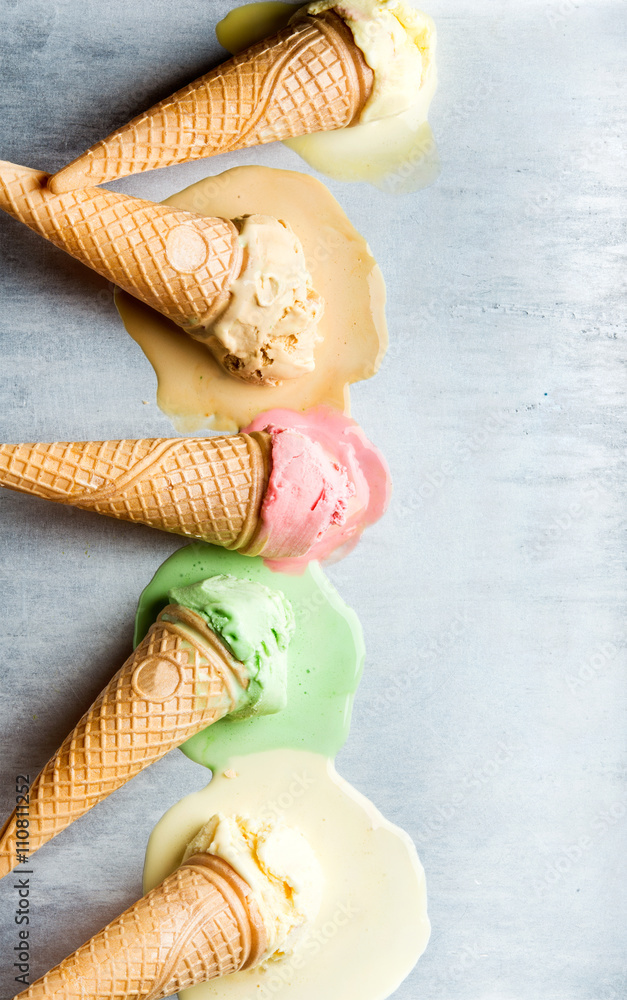Colorful ice cream cones of different flavors. Melting scoops. Top view,  steel metal background