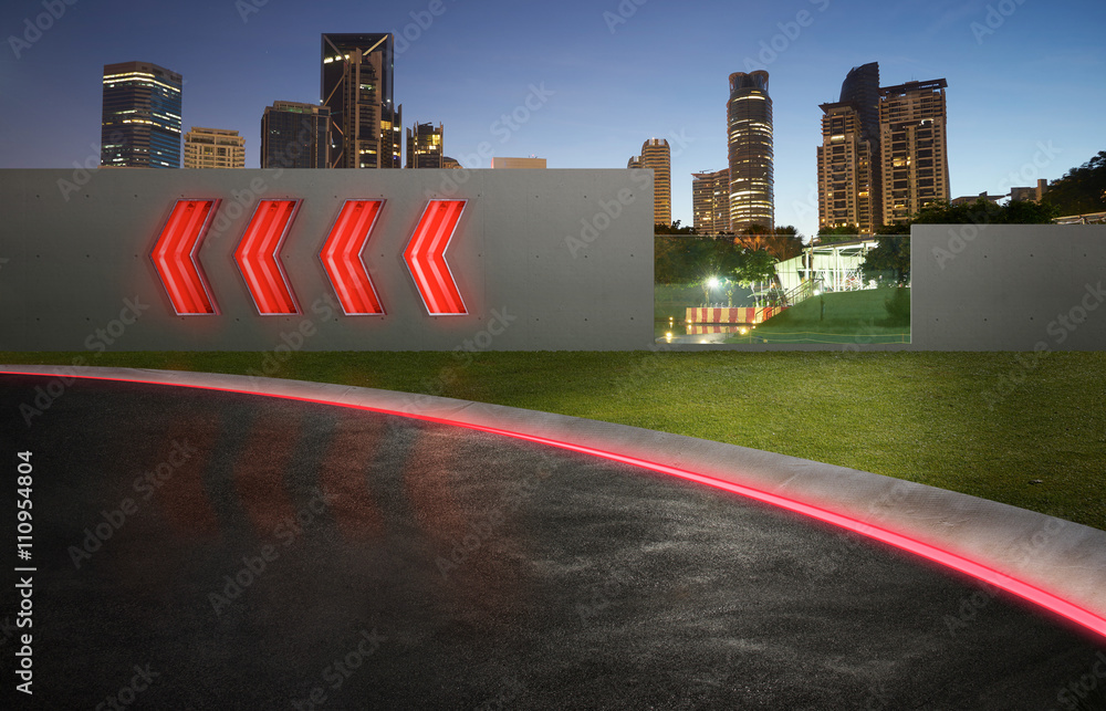 带箭头荧光灯标志和城市天际线背景的沥青路