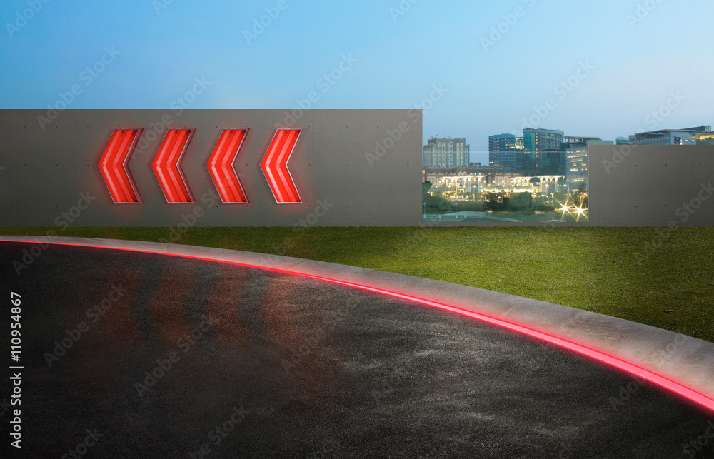 带箭头荧光灯标志和城市天际线背景的沥青路