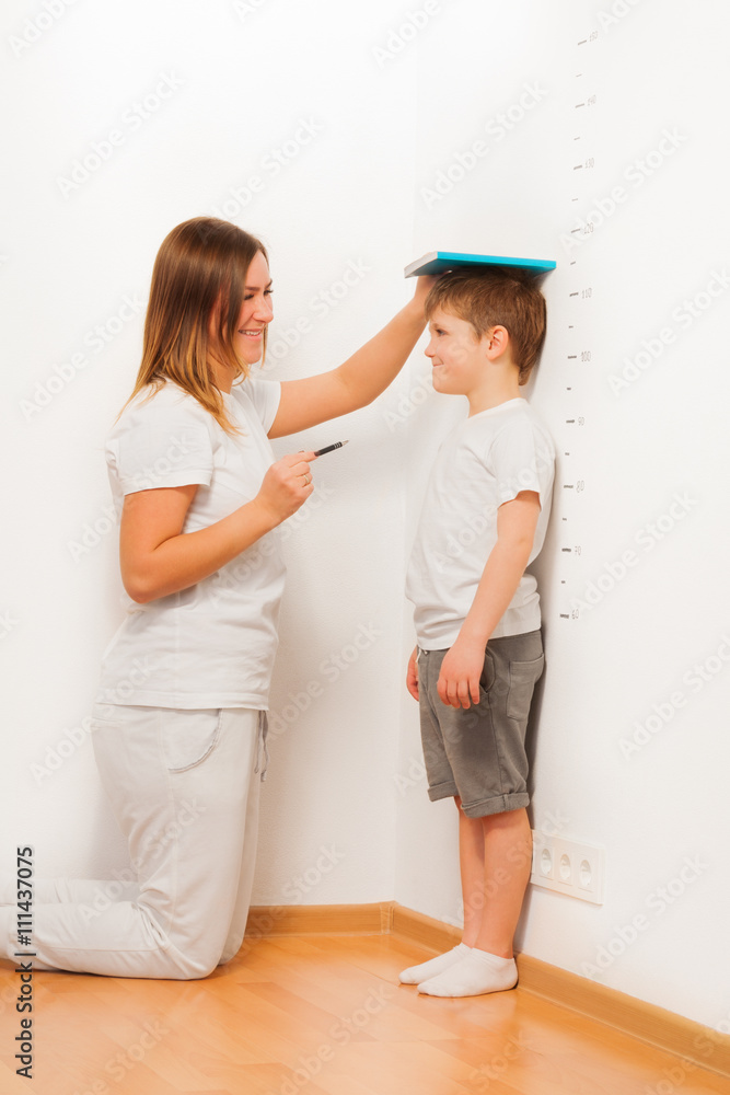 母亲在生长图上检查儿子的身高