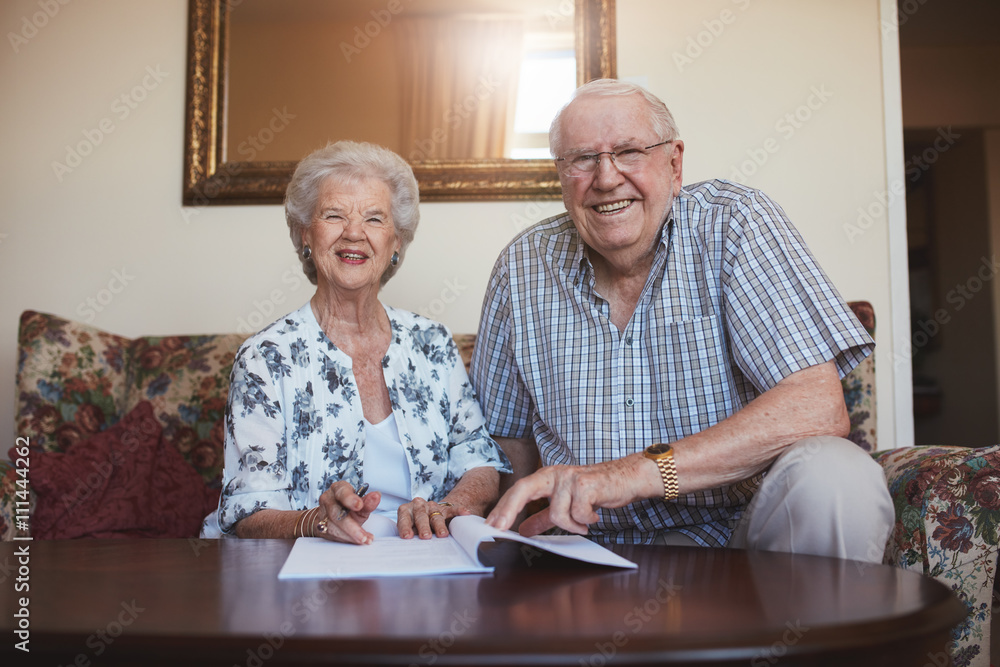 Smiling retired couple looking over documents