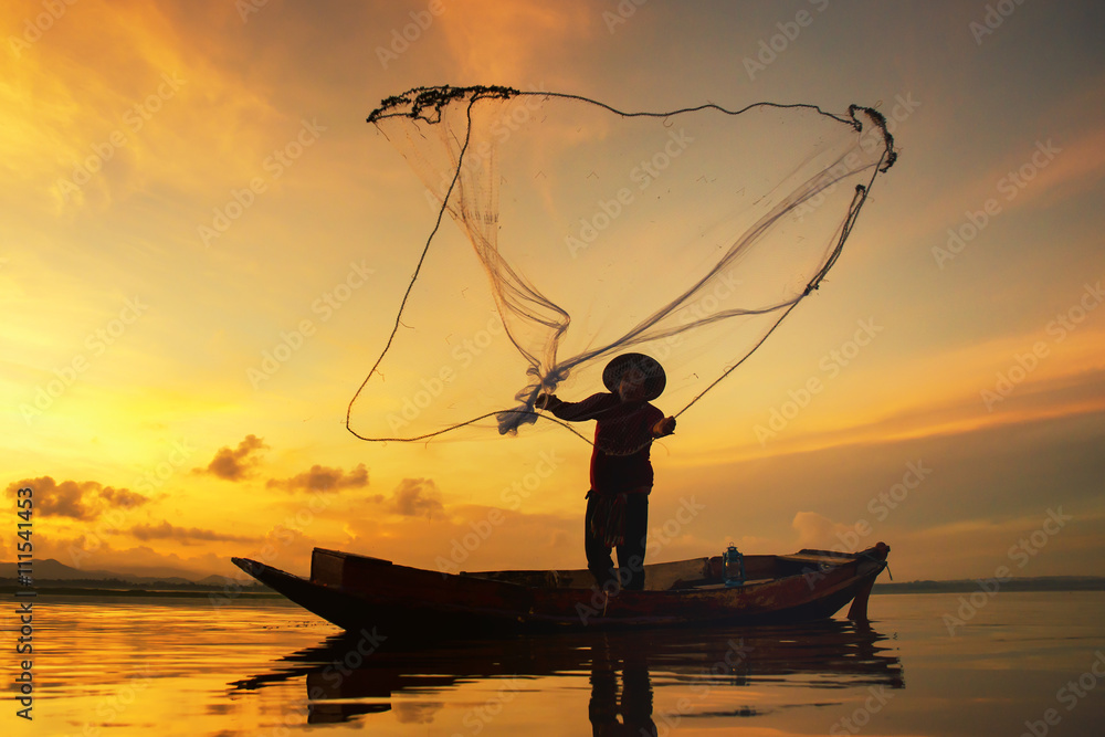 Fisherman fishing at lake in Morning, Thailand.