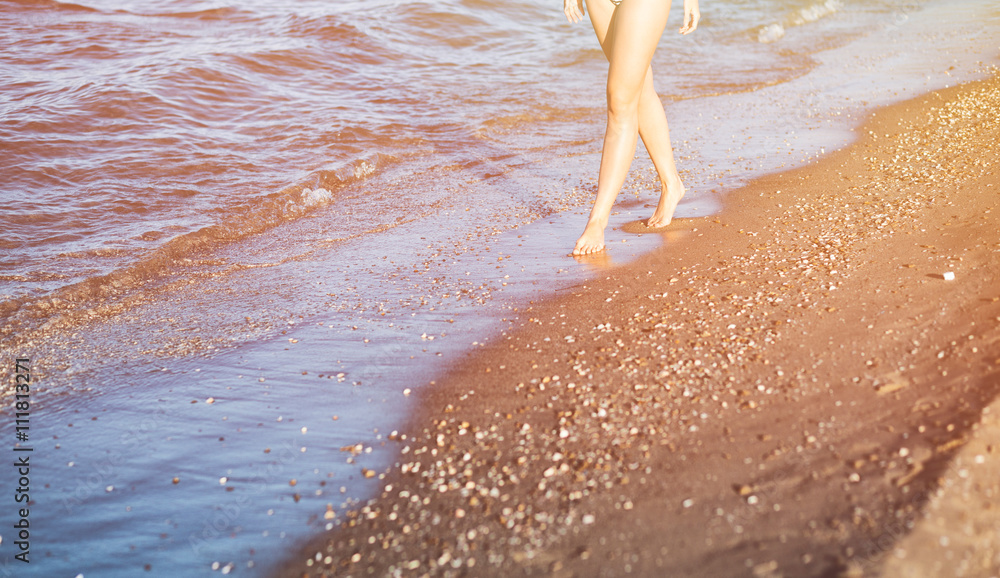 夏日阳光下走在沙滩上的女人，享受假期