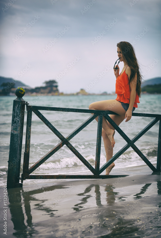 度假时坐在海滩上的年轻女子