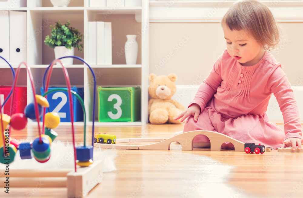 Happy toddler girl playing with toys