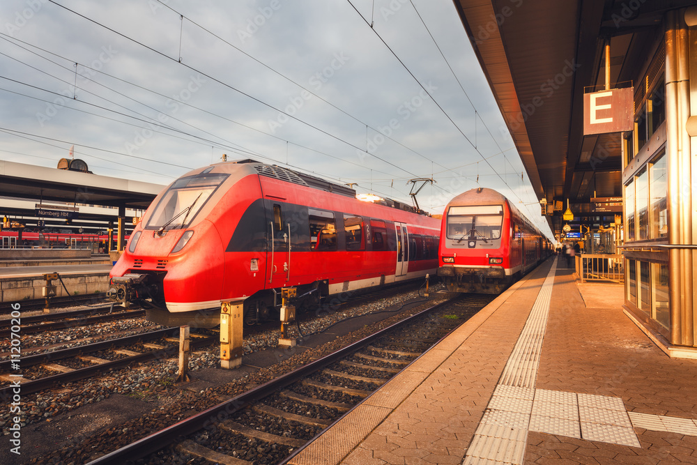 德国纽伦堡美丽的火车站，在五彩缤纷的日落下，有现代化的红色通勤列车。R