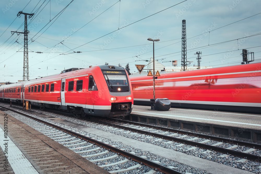 德国纽伦堡日落时分的火车站，有现代化的红色客运列车。有文塔的铁路