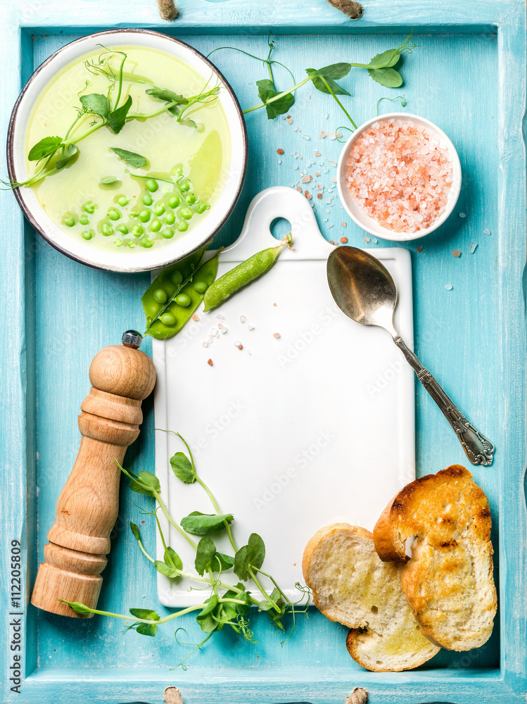 浅夏绿色豌豆奶油汤，碗里有芽菜、烤面包和香料。俯视图，复制spac