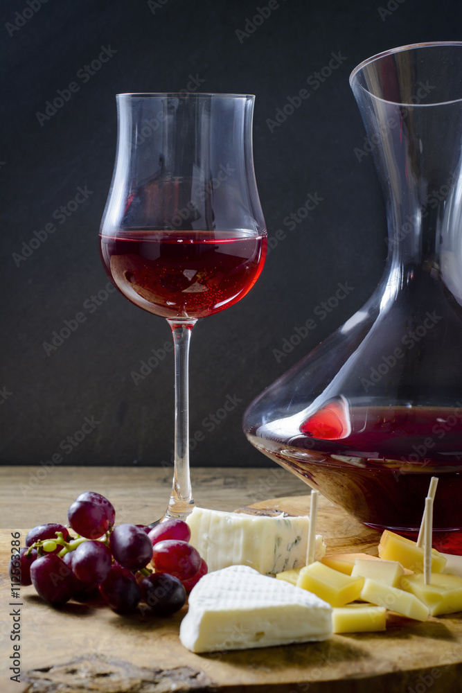 Käsesorten und Wein vor dunklem Hintergrund