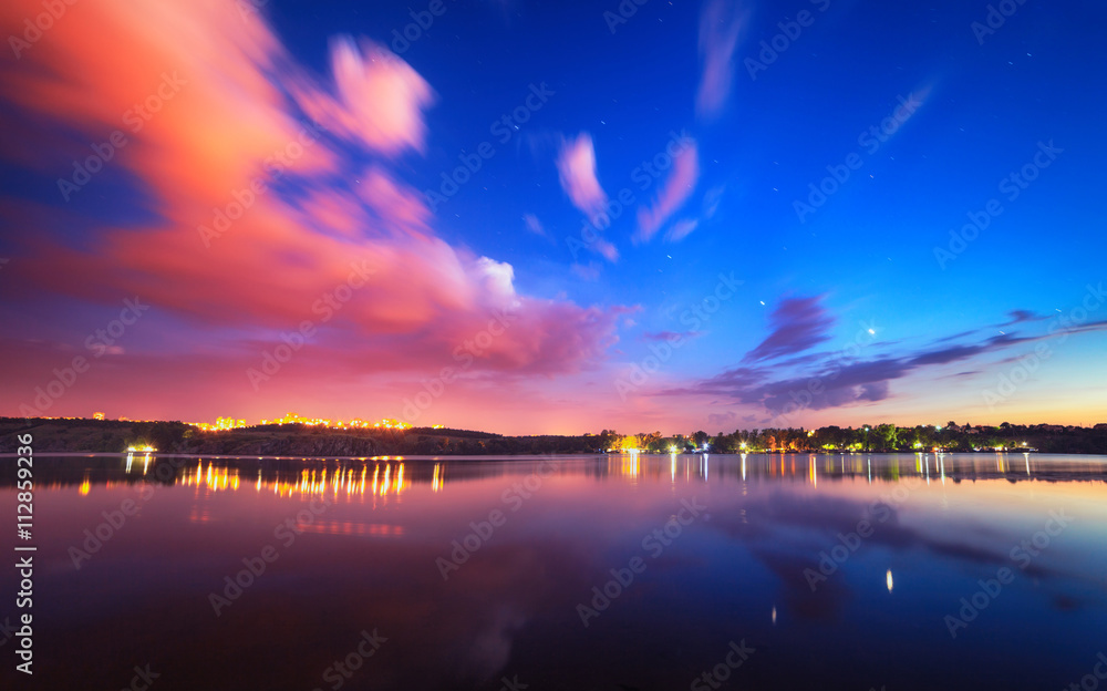湖面上色彩缤纷的夜景，蓝天白云映水中。大自然回来了