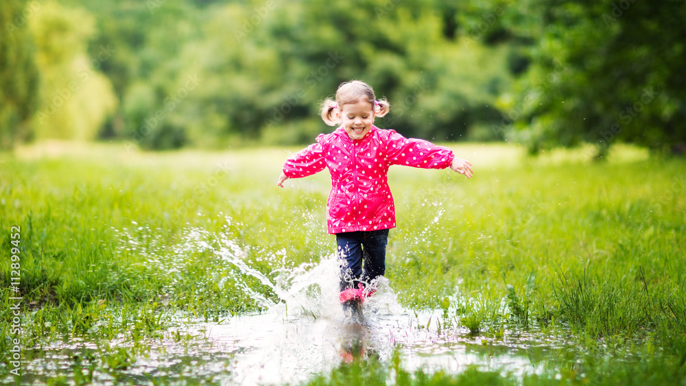 雨后快乐的小女孩在水坑里奔跑和跳跃