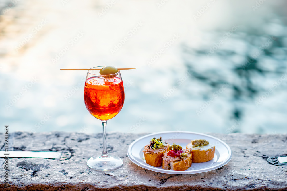 雪碧Aperol饮料配威尼斯传统小吃cicchetti，以威尼斯的水通道为背景