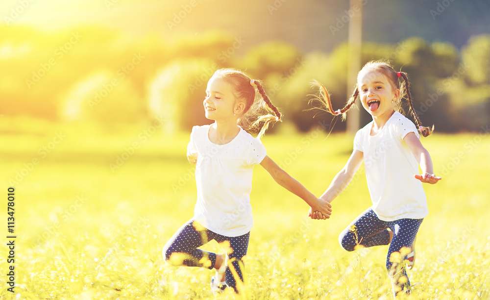 快乐的孩子双胞胎姐妹在户外跑步玩耍