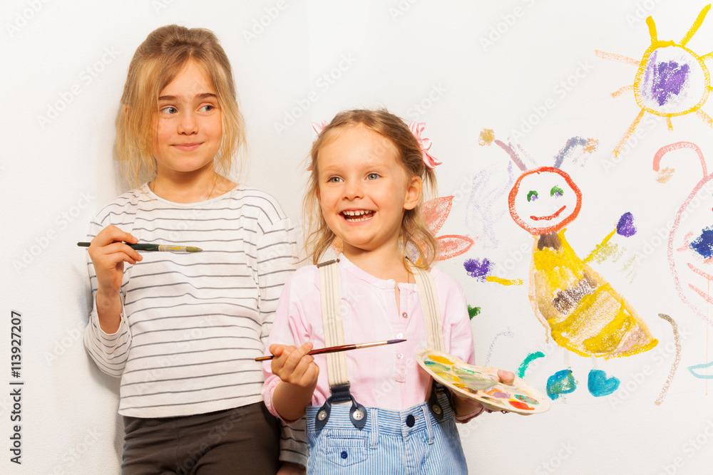 Two smiling painters drawing funny picture