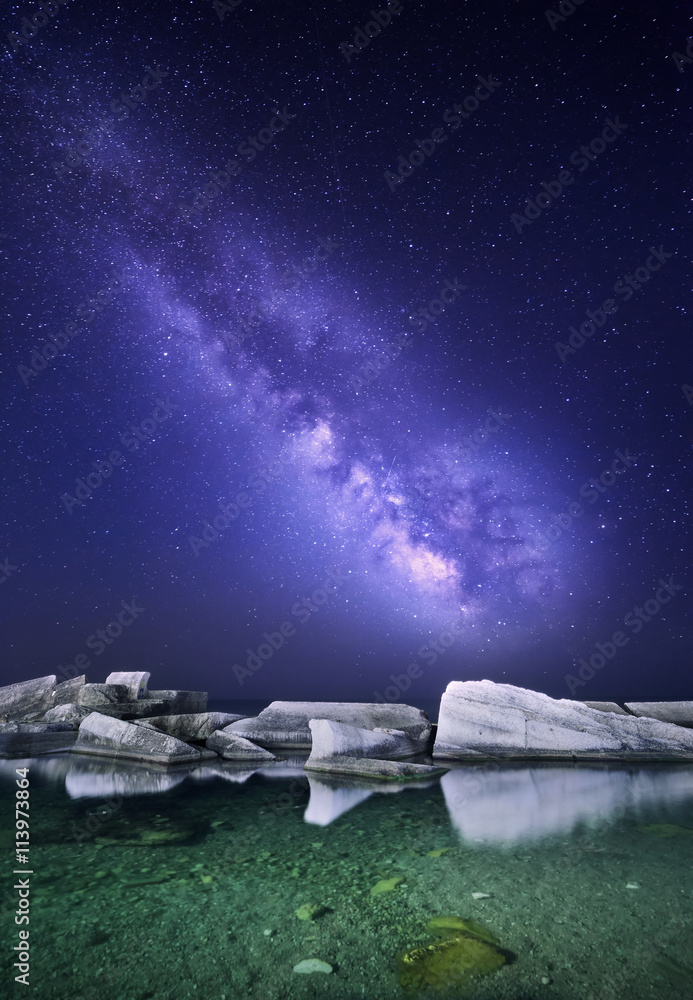 夜晚的风景，海边有五颜六色的银河，有石头。星空。太空背景