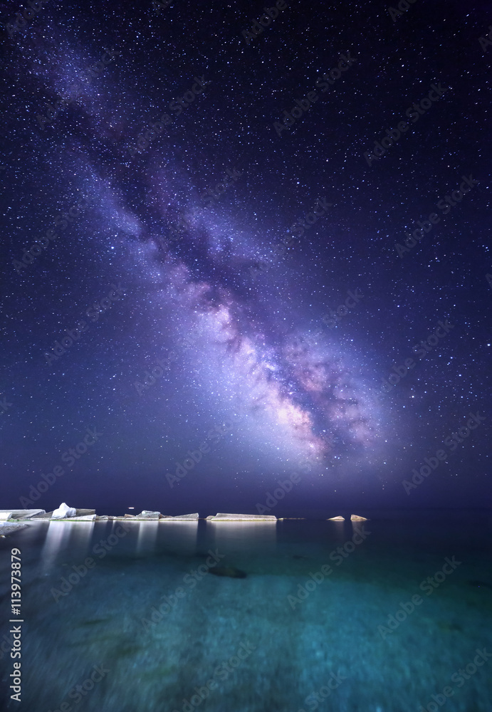 夜晚的风景，海边有五颜六色的银河，有石头。星空。太空背景