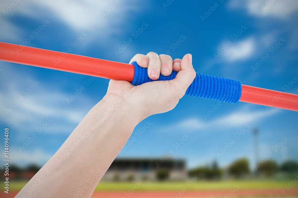 Composite image of close up of a hand holding a javelin