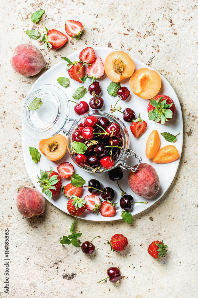 健康的夏季水果品种。甜樱桃、草莓、桃子、杏子和薄荷叶