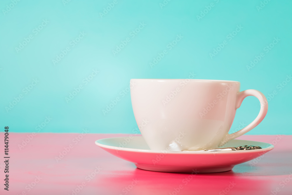 亮粉色和蓝色背景的白色咖啡杯