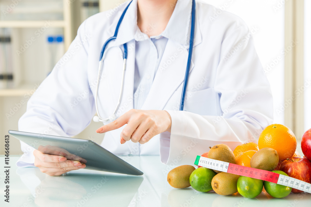 Young asian nutritionist doctor using digital tablet