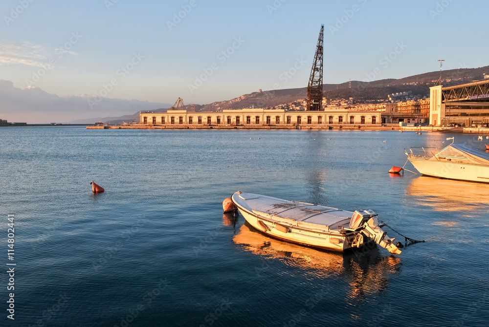 A small boat moored at the harbor of Trieste before the sunset